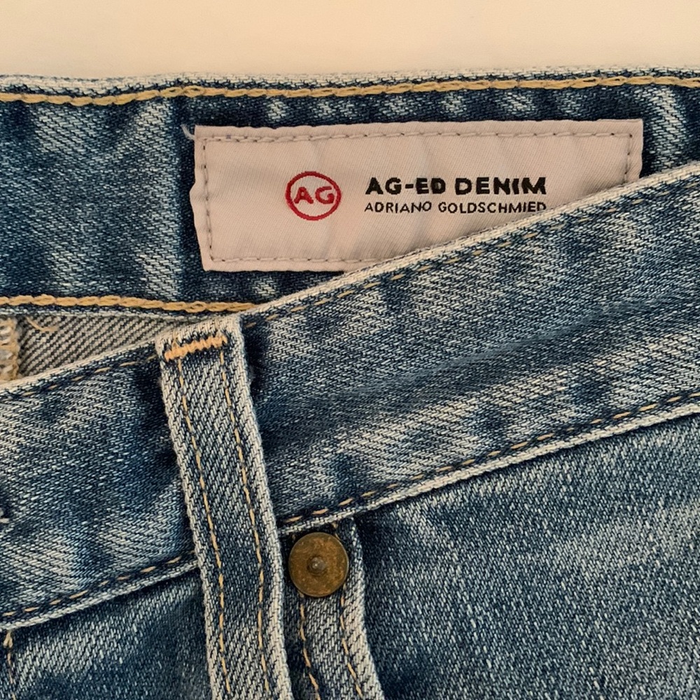 AG jeans, mini jean skirt with frayed bottom, light denim color.
